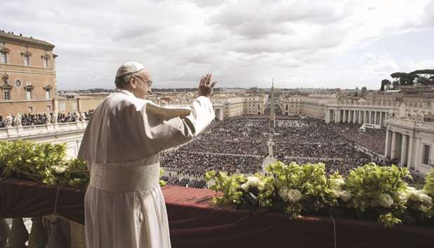 In this handout picture released by the Vatican press office, Pope Francis waves to the crowd during his delivery of the u2018Urbi et Orbiu2019 blessing to the city and to the world from the balcony of St Peteru2019s Basilica, following Easter Sunday Mass.