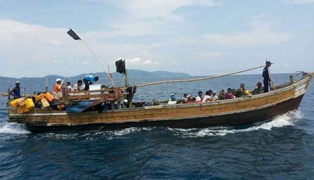 A wooden boat carrying Rohingya refugees being guided by Royal Thai Navy personnel as it sails towards Thailand-Malaysia sea boundary.
