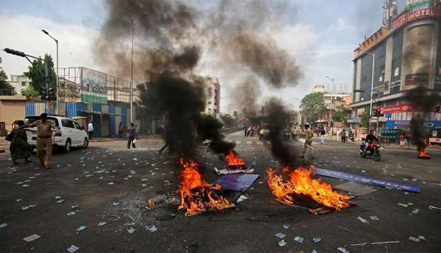 Police officers patrol a street after people belonging to the Dalit community burned tyres and hoardings during a nationwide strike called by Dalit organisations, in Ahmedabad