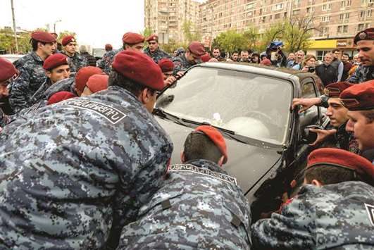 Armenian police officers remove a vehicle during a protest rally in central Yerevan.