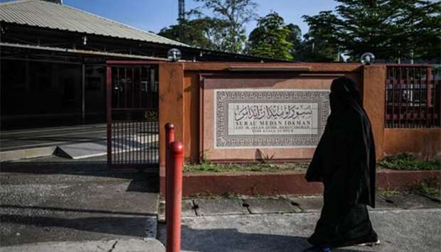A woman walks past a mosque where Palestinian scientist Fadi al-Batsh was headed to when he was gunned down, in Kuala Lumpur on Sunday.