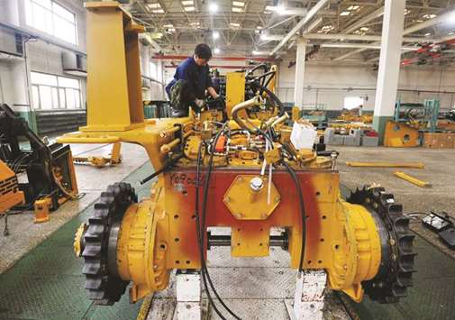 A Chinese employee working on a bulldozer at a factory in Zhangjiakou, Hebei province. Chinese manufacturing activity slowed in March as weak demand weighed on the worldu2019s second largest economy, independent data showed yesterday.