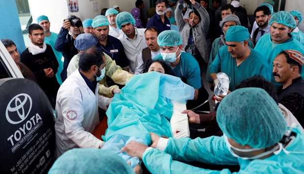 Medics carry an injured woman to the ambulance at a hospital after a suicide attack in Kabul, Afghanistan