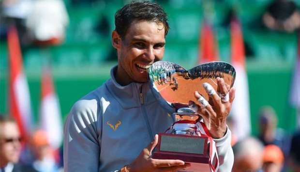 Spain's Rafael Nadal holds the trophy as he celebrates his win in the final match at the Monte-Carlo ATP Masters Series tournament