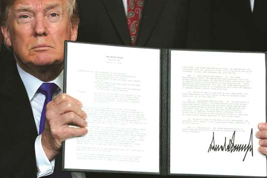US President Donald Trump holds a signed memorandum on intellectual property tariffs on high-tech goods from China at the White House in Washington. China is moving swiftly with retaliatory action amid escalating trade tension with the US, which has rocked global financial markets in the past week as investors fear a full-blown trade dispute between them will damage world growth.