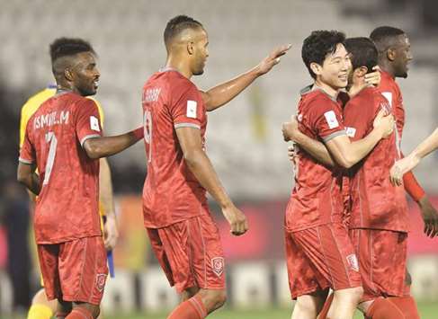 (From left) Al Duhailu2019s Ismail Mohamed, Youssef El Arabi and Nam Tae-Hee celebrate their victory over Al Gharafa in the Qatar Cup football semi-final at Al Sadd Stadium yesterday. PICTURES: Noushad Thekkayil and Shemeer Rasheed