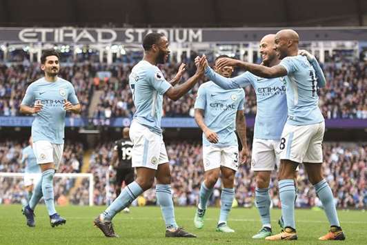Manchester Cityu2019s Raheem Sterling (left) celebrates with teammates after scoring against Swansea during the English Premier League match at the Etihad Stadium in Manchester, north west England, yesterday. (AFP)