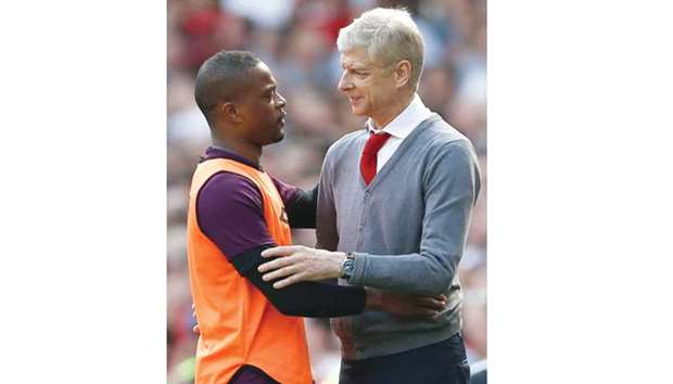 Arsenal manager Arsene Wenger is greeted by West Ham Unitedu2019s defender Patrice Evra during the Premier League match yesterday. (AFP)