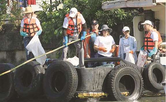 Canadian ambassador John Holmes and other volunteers collect garbage during the Pasig River clean-up drive.