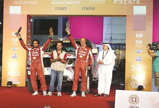 Qataru2019s Adel Abdulla (second from right) and co-driver Nasser al-Kuwari (left) finished third in the Manateq Qatar Baja yesterday. PICTURE: Othman Iraqi