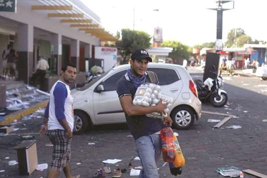 A man with goods looted from a store walks along a street after protests over a controversial reform to the pension plans of the Nicaraguan Social Security Institute (INSS) in Managua, Nicaragua, yesterday.
