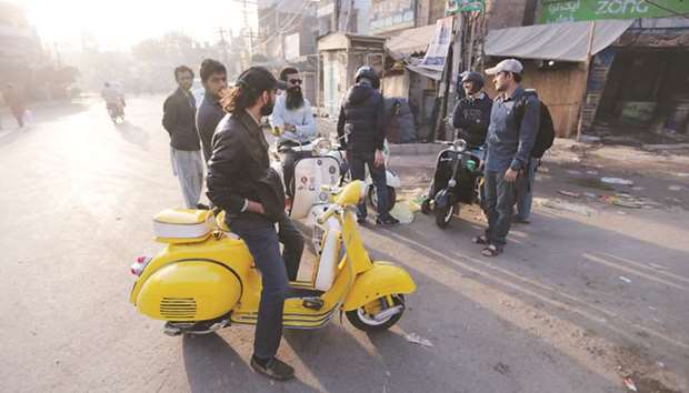 Members of a Vespa rideru2019s club gather at sunrise for a ride in Lahore.