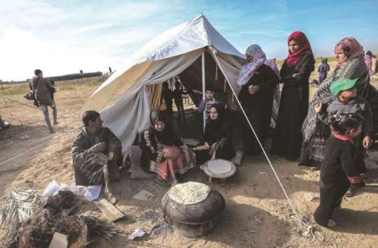Palestinian women bake bread near the border with Israel, east of Khan Yunis, in the southern Gaza Strip, yesterday.