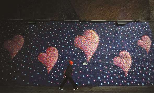 A woman walks past a mural by British-born Australian artist James Cochran, painted to commemorate the victims of the London Bridge attack, in London yesterday.