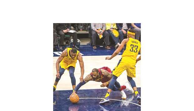 Cleveland Cavaliersu2019 LeBron James (centre) dives for a loose ball in front of Indiana Pacersu2019 Thaddeus Young (left) and Myles Turner in game four of the first round of the 2018 NBA Playoffs in Indianapolis on Sunday. (USA TODAY Sports)