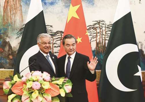 Foreign Minister Khawaja Muhammad Asif with Chinese State Councillor and Foreign Minister Wang Yi at the Diaoyutai State Guest House in Beijing yesterday.