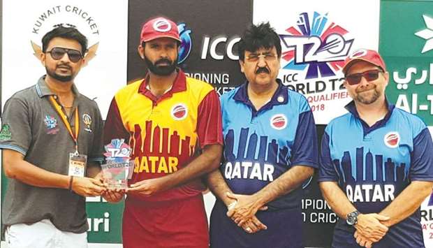 Mohamed Tanveer of Qatar receives the man of the match award as team Manager Gul Khan Jadoun (second right) and Qatar coach Simon Gough (right) look on.