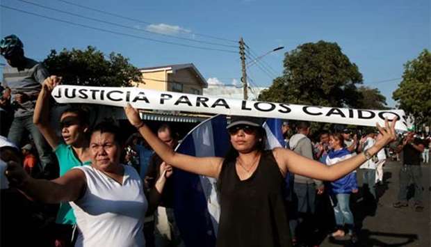 Demonstrators show a sign during a protest against police violence and the government of Nicaraguan President Daniel Ortega in Managua on Monday.