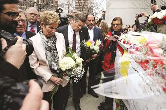 Ontario Premier Kathleen Wynne and Toronto Mayor John Tory brings flowers yesterday to a makeshift memorial for victims in the van attack in Toronto.
