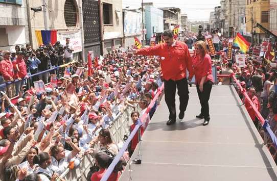 Venezuelau2019s President Nicolas Maduro and his wife Cilia Flores greet supporters during a campaign rally in Ciudad Guayana, Venezuela.