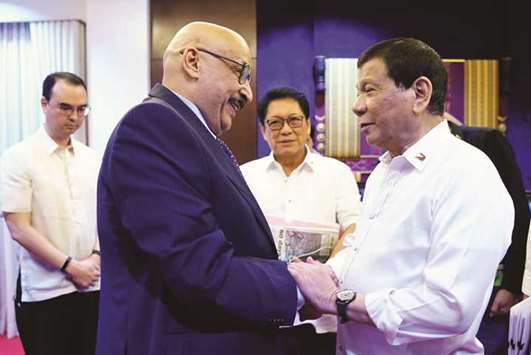 This handout photo received from the Presidential Photo Division (PPD) yesterday, shows President Rodrigo Duterte  meeting Kuwaiti ambassador to the Philippines Musaed Saleh Ahmad Althwaikh (left) at the presidential guest house in Davao City, in the southern island of Mindanao, as Foreign Secretary Alan Cayetano (back, left) and Labour Secretary Silvestre Bello III (back, centre) look on.