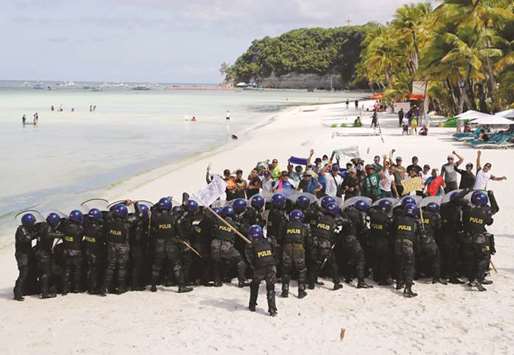 Policemen take part during a simulation of a protest during a military and police drill in preparation for the temporary closure of the holiday island Boracay, yesterday.