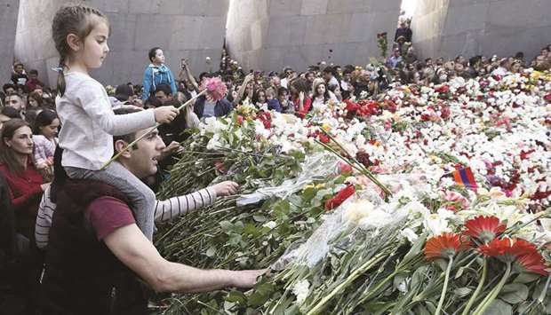 People lay flowers to commemorate the 103rd anniversary of mass killing of Armenians by Ottoman Turks, at the Tsitsernakaberd Memorial Complex in Yerevan.