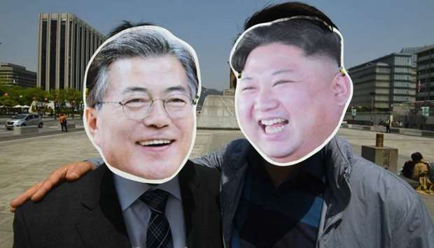 South Korean activists wearing masks of South Korean President Moon Jae-in (L) and North Korean leader Kim Jong Un (R) pose for a photo during a rally to support the upcoming inter-Korean summit, at Gwanghwamun square in Seoul.