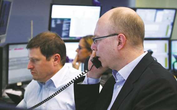 Traders look at their screens at the Frankfurt Stock Exchange. The DAX 30 lost 1% to 12,422.30 points yesterday.