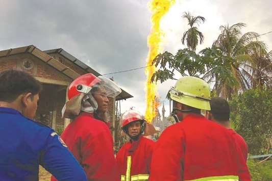 Firefighters work near the site of a fire at an oil well in Peureulak, Indonesiau2019s Aceh province, yesterday.