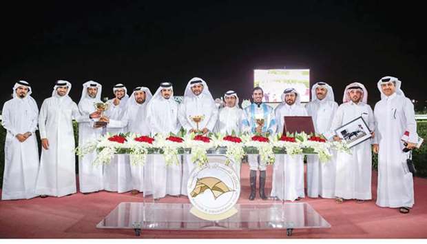 Ahmed bin Saeed al-Kuwari (sixth from left), Qatar Racing and Equestrian Club (QREC) deputy chief steward Abdulla al-Kubaisi (sixth from right) and Saad al-Hajri (fourth from right), head of Grandstand and Protocol, with the winners of Club Cup (The Late Saeed Bin Ahmed Al Kuwari Cup) after Mohanad Jassim al-Yaqoutu2019s MJ Lattam won the six-furlong feature at the QREC yesterday. PICTURES: Juhaim