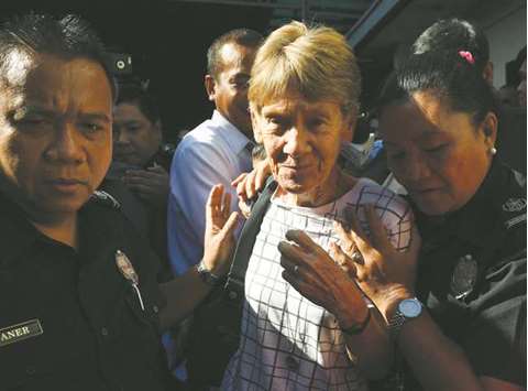 A recent photo shows Australian nun Sister Patricia Fox (centre) being escorted by immigration officers while leaving a detention facility after her release at the Immigration headquarters in Manila, a day after she was arrested.