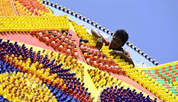 A worker adjusts lightbulbs on a pandal, a coloured structure illuminated with bulbs, in Colombo. Sri Lankan Buddhists are preparing to celebrate Vesak, which commemorates the birth of Buddha.