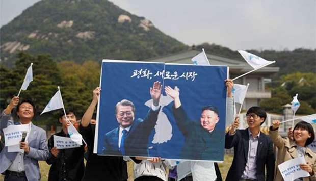 Students hold posters with pictures of South Korea\'s President Moon Jae-in and North Korea\'s leader Kim Jong Un during a pro-unification rally ahead of the summit, in Seoul on Thursday.
