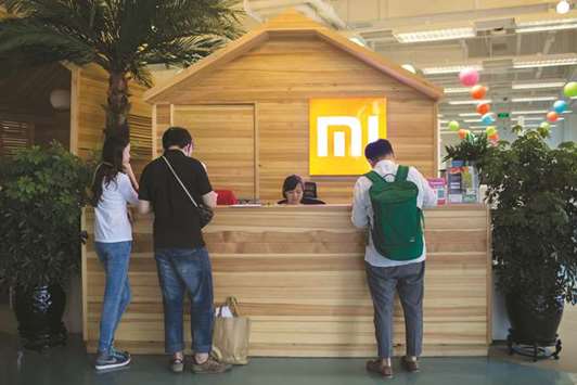 Visitors stand at a reception desk inside a Xiaomi Corp office in Beijing (file). Xiaomi is close to filing for its IPO in Hong Kong and also plans to issue Chinese depositary receipts for mainland investors.