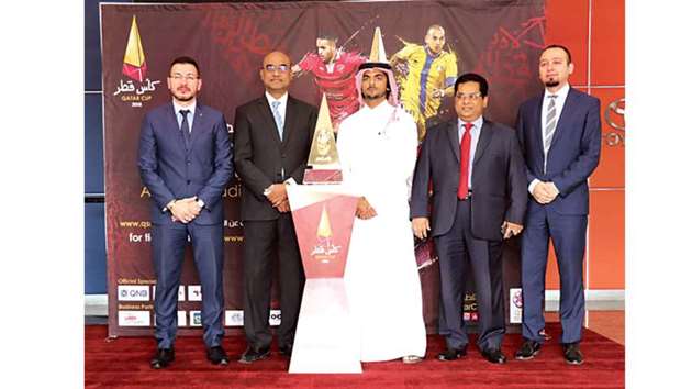 Acting CEO of Abdullah Abdulghani & Bros. Co (second left) and Head of Sales from Qatar Stars League Meshaal Abdulaziz al-Emadi (third from left) pose with the Qatar Cup Trophy at Toyota Showroom.