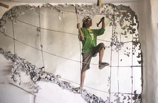 A worker demolishes a wall of the West Cove Hotel on the Philippine island of Boracay yesterday.
