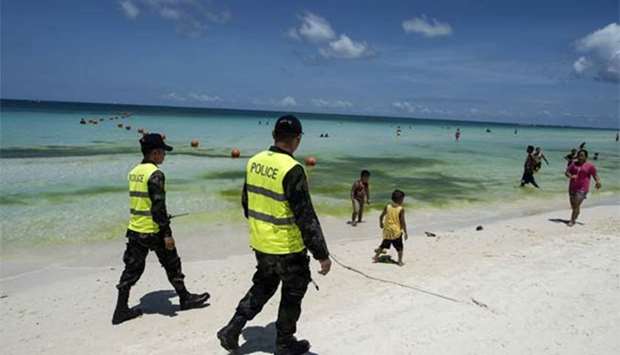 Policemen patrol the beach in Boracay on Thursday.