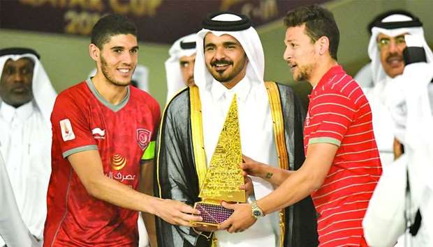 HE Sheikh Joaan bin Hamad al-Thani, President of the Qatar Olympic Committee, presents the Qatar Cup trophy to Al Duhail's winning captain Karim Boudiaf (left) and midfielder Youssef Msakni (right). Duhail beat defending champions 2-1 in the final at Al Sadd stadium yesterday. PICTURE: Noushad Thekkayil