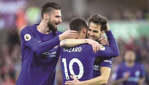 Chelseau2019s Cesc Fabregas (right) celebrates with teammates Eden Hazard and Olivier Giroud (left) after scoring against Swansea City in the Premier League. (Reuters)