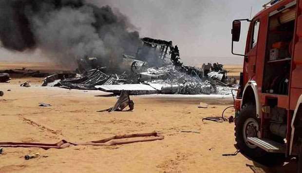 Smoke emanates from the remnants of the crashed aircraft