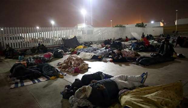 Members of a caravan of migrants from Central America sleep near the San Ysidro checkpoint in Tijuana