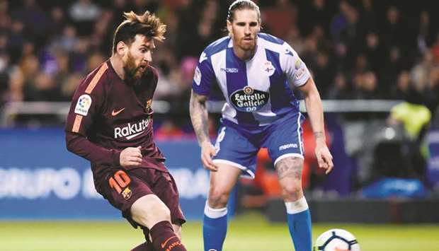Barcelonau2019s Lionel Messi (left) scores during the Spanish La Liga match against Deportivo Coruna on Sunday night. (AFP)