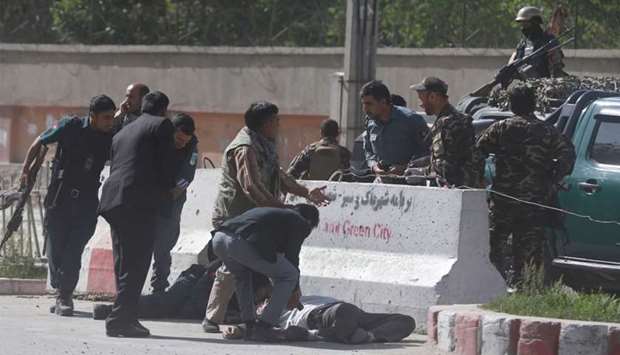 Policemen help Afghan journalists, victims of a second blast, in Kabul