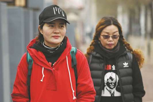Li Wenzu (left), the wife of detained human rights lawyer Wang Quanzhang, walks with supporter Lin Ermin (R), the wife of rights activist Zhai Yanmin, who was sentenced to a suspended three year prison sentence in August 2016, on the outskirts of Beijing yesterday.