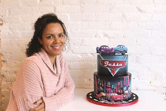 BAKER: Miriam Milord poses with one of her custom-made creations, a cake based on the film Cars, at her bakery in New York.