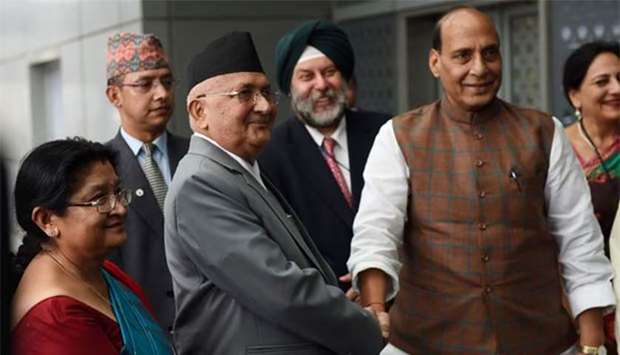 Nepal's Prime Minister K P Sharma Oli shakes hands with Indian Home Minister Rajnath Singh upon his arrival at the Indira Gandhi international airport in New Delhi on Friday.