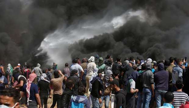 Palestinian demonstrators gather at the Israel-Gaza border during clashes with Israeli troops at a protest demanding the right to return to their homeland, east of Gaza City.