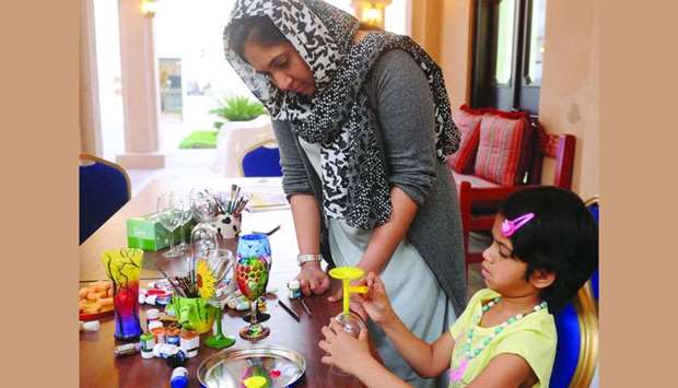 A young girl learns the art of glass painting from Liji Abdullah. PICTURE: Shemeer Rasheed.