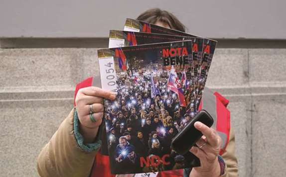 A vendor sells the Nota Bene street magazine with a cover showing a protest held to demand the resignation of the Slovak police chief Tibor Gaspar.